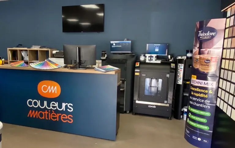 Choisir sa couleur de peinture : nuanciers de peinture ouverts sur le comptoir du showroom